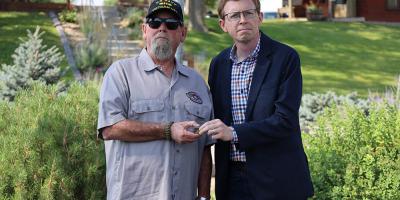 Johnson handing a pin to a veteran