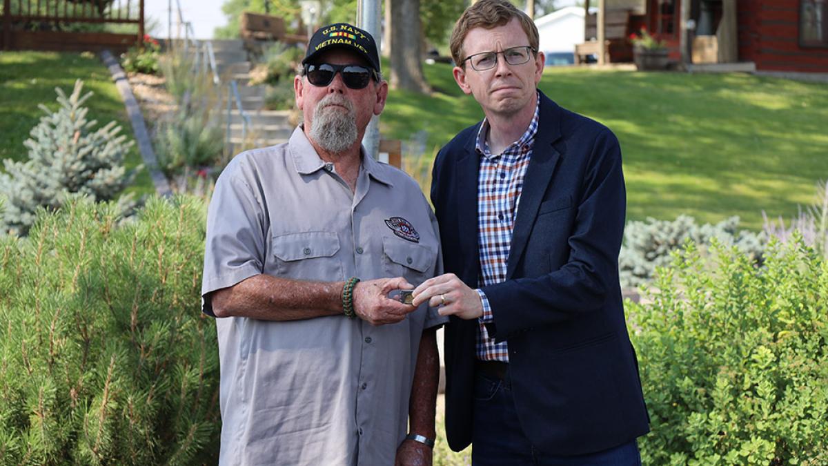 Johnson handing a pin to a veteran